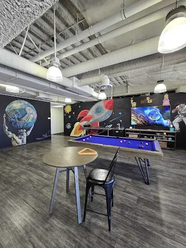 Inside the Max Market Pros workspace — murals, a pool table, and a creative open-plan studio in Irvine